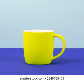 New Yellow Cup On Solid Pastel Background. Blue Background