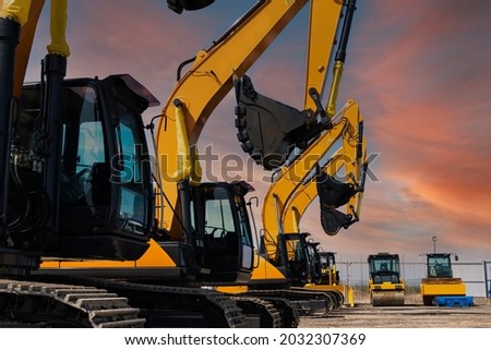 New Yellow Excavators are lined up in an open area. High quality photo