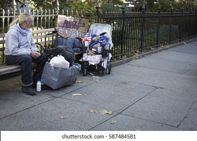 NEW YORK - 11 NOV 2016: A homeless US Army veteran sits on a park bench outside the opening ceremony in Madison Square Park before the annual Americas Parade on Veterans Day in Manhattan.