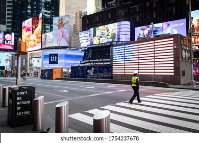 New York, New York - April 5, 2020: NYPD Officer Walks In Times Square, Empty & Void Of Tourists; Theaters/restaurants/businesses Have Been Shut Down To Prevent The Spread Of COVID-19.