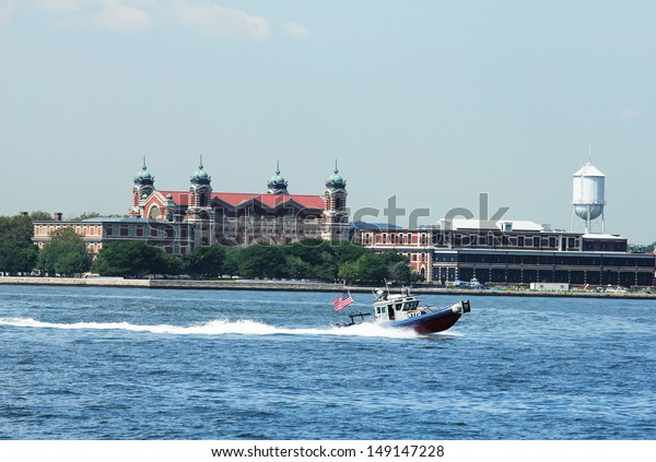 NEW YORK - AUGUST 6:NYPD\
boat patrolling New York Harbor in the front of Ellis Island    on\
August 6, 2013. NYPD on high alert after terror threat in New York\
City
