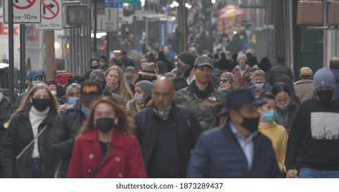 NEW YORK - CIRCA DECEMBER 2020: Crowd of people wearing masks walking street during Covid 19 pandemic