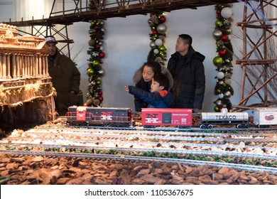 New York City - 13 January 2018: Little Asian Boy Points To Show Something To His Grandmother While A Model Train Goes By At The New York Botanical Garden Holiday Train Show In The Bronx. 