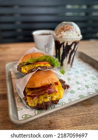 New York City -2022: Shake Shack Is An American Fast Casual Restaurant Chain Based In New York City. Shack Burger, Smoke Shack Burger, Drink, And Chocolate Churro Shake. Selective Focus.