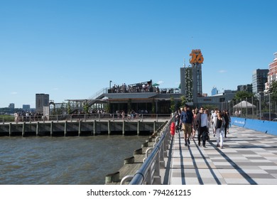 New York City - 3 June 2017: People on the trendy rooftop of City Vineyard on Pier 26 in Lower Manhattan. People enjoying the good weather on a rooftop. People walking along Pier 26.