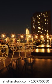 New York City - 30 August 2017: People on the chic rooftop bar The Crown in the Bowery at night in Lower Manhattan. Lights of New York City and New York skyscrapers in the background.