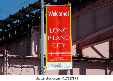 New York City - August 10, 2008:  Welcome To Long Island City BID Banner Hangs From A Lamp Post Underneath Subway Elevated Tracks Near Queens Plaza