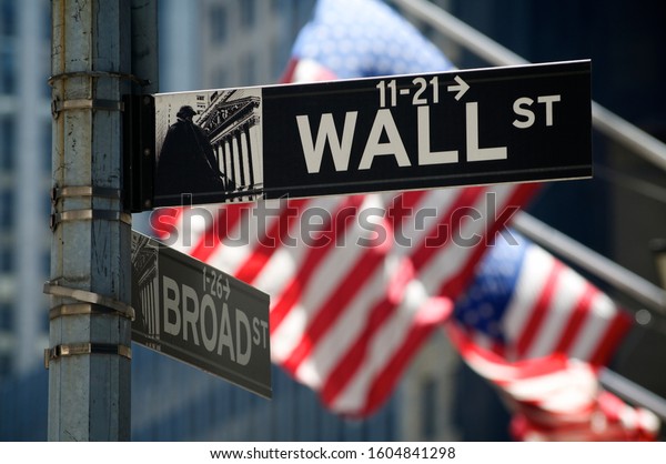 NEW YORK CITY - AUGUST 7, 2010: American flags fly behind a sign for Wall Street, symbol of American capitalism.