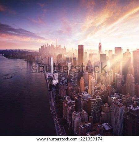 New York City - beautiful colorful sunset over manhattan fit sunbeams between buildings