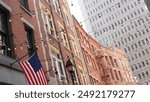 New York City building architecture. Residential house exterior. Real estate property, USA flag. Typical red brick facade. Manhattan downtown financial district, Stone street, FiDi. Fire escape ladder