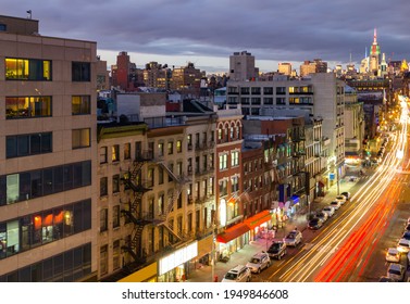 New York City Busy Overhead Street View Of Bowery Through The Buildings Of Chinatown With Car Lights Streaking Down The Road From Long Exposure At Night