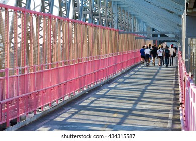NEW YORK CITY - CIRCA 2015: People run across the Williamsburg Bridge footpath at sunset in New York City 2015. The bridge connects the Lower East Side of Manhattan with Williamsburg in Brooklyn.