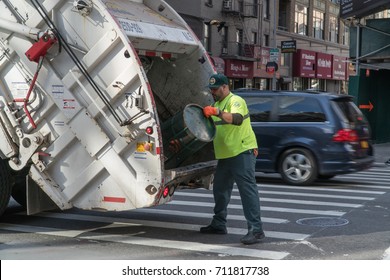 New York City, Circa 2017: DSNY Sanitation Department Workers Empty Trash Can Into Garbage Truck To Keep Street Clean