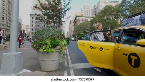 New York City, Circa 2017: Young Blonde Woman Get In NYC Yellow Taxi Cab Hail On Street To Pay Fare For Ride To Airport With Luggage