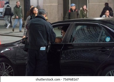 New York City, Circa 2017: NYPD Police Officer Pulls Over Livery Cab Driver And Checks License And Registration Identification. Night Time During Rush Hour On Manhattan Street