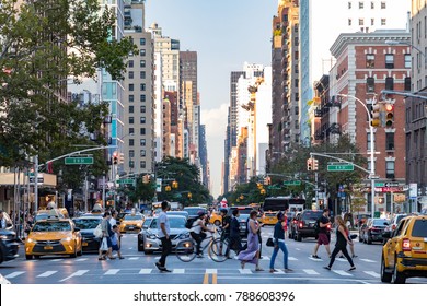 NEW YORK CITY - CIRCA 2017: Busy Crowds Of People Walk Across 3rd Avenue In Front Of Rush Hour Traffic In The East Village Neighborhood Of Manhattan In New York City.