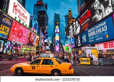 NEW YORK CITY - CIRCA AUGUST, 2018: A yellow taxi passes under the bright flashing lights of Broadway and tourist crowds of Times Square.