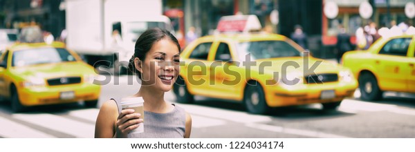 New York city commute - Asian business woman\
walking to work in the morning commuting drinking coffee cup on NYC\
street with yellow cabs in the background banner. People commuters\
lifestyle.
