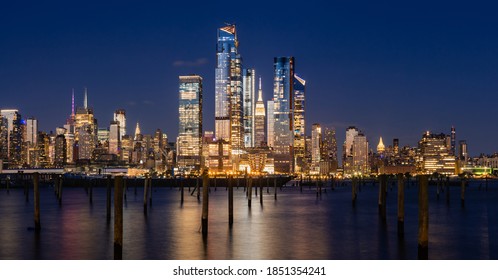 New York City evening panoramic of Manhattan Midtown West skyline with illuminated Hudson Yards skyscrapers from the Hudson River. NYC, USA
