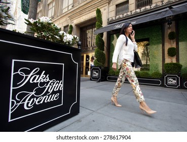 NEW YORK CITY - FRIDAY, MAY 8, 2015: Pedestrians walk past Saks Fifth Avenue in Manhattan. Saks Fifth Avenue is an American department store chain owned by the Hudson's Bay Company.