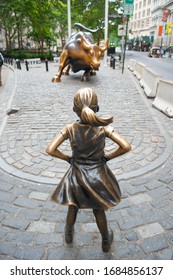 NEW YORK CITY - JUL. 14, 2018: Fearless Girl statue in front of Wall Street Bull Charging Bull at Wall Street in Manhattan, New York City NYC, New York NY, USA.