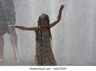 NEW YORK CITY - JULY 6 2013: The fountain at Washington Square Park becomes a major destination for overheated New Yorkers seeking escape from the summer heat on July 6 2013 in New York City.