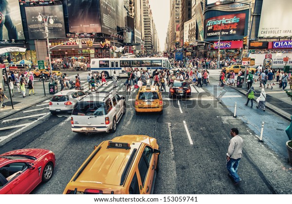 NEW YORK CITY - JUN 11: Undefined people pass through\
Times Square on June 11, 2013 in New York. Times Square is a major\
commercial intersection in Manhattan, at the junction of Broadway\
and 7th Ave