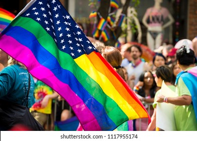 NEW YORK CITY - JUNE 25, 2017: American Flag With Stars And Gay Pride Rainbow Stripes Being Waved At The Annual Gay Pride Parade In Greenwich Village, NYC