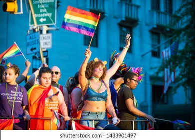 NEW YORK CITY - JUNE 25, 2017: Participants Wearing Shirts Sponsored By Montefiore Medical Center Wave Flags On A Float In The Gay Pride Parade In Greenwich Village.