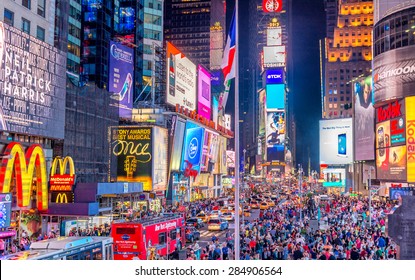 NEW YORK CITY - JUNE 8, 2013: Tourists in Times Square at night. More than 50 million people visit New York every year.