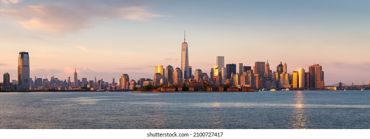 New York City Lower Manhattan skycrapers panoramic view at sunset. Ellis Island in New York Harbor with the World Trade Center