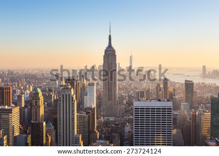 New York City. Manhattan downtown skyline with illuminated Empire State Building and skyscrapers at sunset.