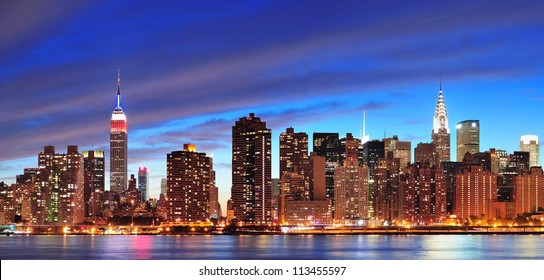 New York City Manhattan midtown panorama at dusk with skyscrapers illuminated over east river - Shutterstock ID 113455597