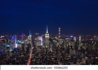 New york city, manhattan skyline at dusk or nighttime with dark cloudy sky and lights. The Empire State Building, Chrysler building and other Midtown high rises and skyscrapers. Cityscape. Urban. 