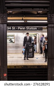 NEW YORK CITY - MARCH 13, 2015:  Scene from historic Penn Station in Manhattan with commuters on subway platform waiting for train.