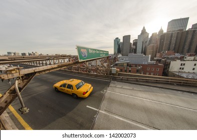 NEW YORK CITY -MARCH 15: Taxi Cab Speeds Up In Brooklyn Bridge. The Bridge Was Initially Designed By German Immigrant John Augustus Roebling, March 15, 2010 In New York City