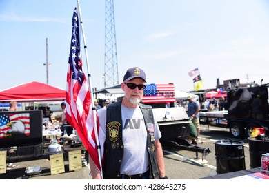 NEW YORK CITY - MAY 25 2016: Ships Of The US Navy Docked In The Brooklyn Ferry Terminal As The 28th Annual Fleet Week Started. Member Of Freedom Riders Motorcycle Club With US Flag