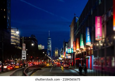 New York City Night Street Scene At Chelsea Pier With Blurred Lights Of The Skyline Buildings And Cars