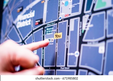 NEW YORK CITY, NY -18 April 2017: The Tourist Looks At The Map Of New York And Shows By The Finger Where He Is Now. New York Has An Extensive System Of Metro Lines And Bus Services.