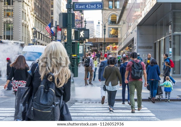 New York City, NY - April 26,2018 : Many people\
walking on E 42nd St with building in the background in New York\
City, NY on April 26,2018.