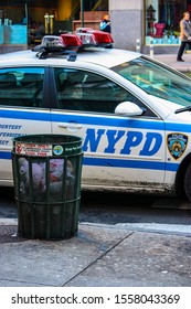 NEW YORK CITY, NY - DEC 22, 2009: Two Policemen In Their Car Next To A Trash Can