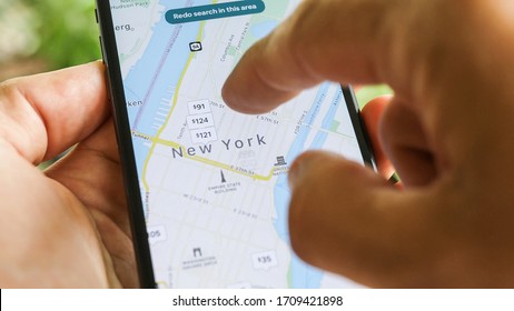 NEW YORK CITY, NY – December 1, 2019:  Female Hand Holding Smartphone With Airbnb Application. Woman Trying To Book Home Apartment Room In New York City Using Airbnb App