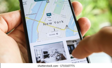 NEW YORK CITY, NY – December 1, 2019:  Female Hand Holding Smartphone With Airbnb Application. Woman Trying To Book Home Apartment Room In New York City Using Airbnb App