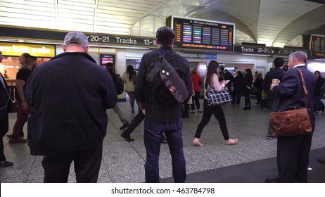 New York City, NY - May 4 2016: Busy commuters wait in Penn Station for Long Island Railroad train to be posted for departure on the board. Viewing track number location