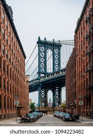 New York City, NY, USA - July 16 2014: The Manhattan bridge from Brooklyn Heights (Washington St and Water St), with the Empire State Building in the background.