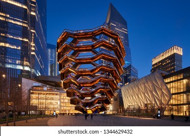 New York City, NY, USA - March 19, 2019: The Vessel, also known as the Hudson Yards Staircase (designed by architect Thomas Heatherwick) at dusk. On the right, The Shed. Midtown Manhattan West.
