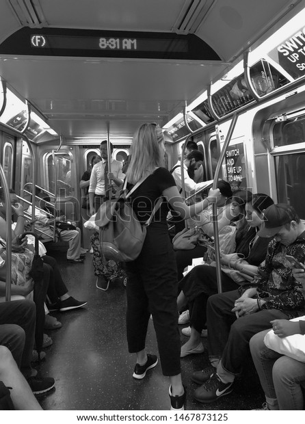 New York City, NY/\
USA: 7-22-19- New York City Subway People Taking Subway Car to Work\
Black and White