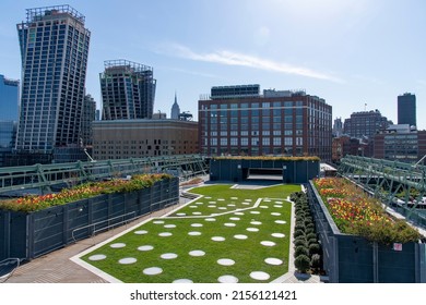 New York City, NY, USA-May 2022; High angle view over Pier 57 Rooftop Park with Empire State building and The XI building in the background