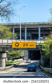 New York City, NY, USA-May 2022; Vertical view of curved ramp (with warning sign) leading to the entrance of the George Washington Bridge, with upper and lower deck visible above