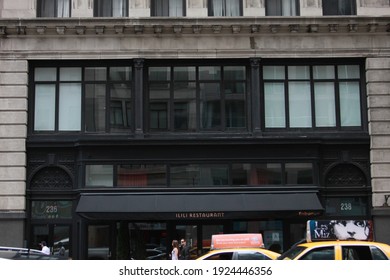 New York City, NY, USA-November 07, 2015: Store Front Of The Ilili Restaurant A Lebanese Mediterranean Food Restaurant In New York City. Taxi Cabs Are Driving By, One With A Les Miserable Advertising